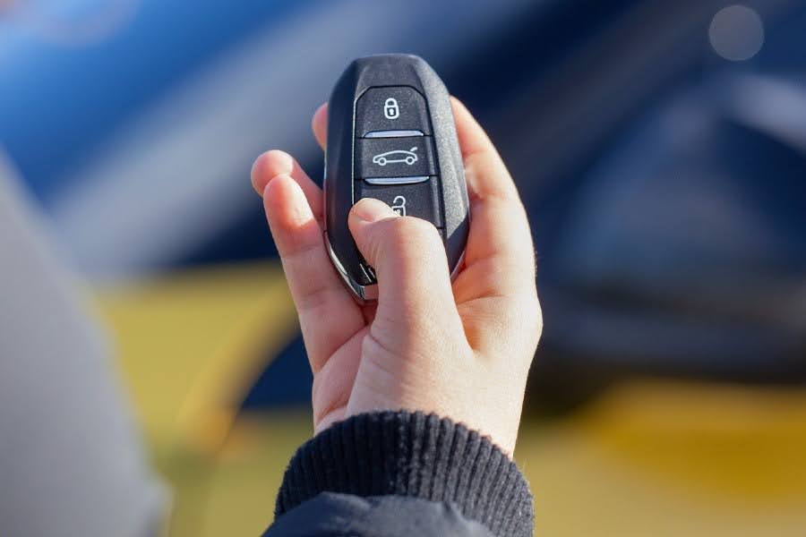 Person holding a car key fob for automotive key identification